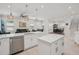 Open-concept kitchen offers an island, stainless appliances, and a view of the living and dining areas at 714 S Lois Ave, Tampa, FL 33609