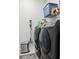 Laundry room features gray washer and dryer set with storage and a sleek silver trash can at 714 S Lois Ave, Tampa, FL 33609