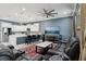 Open-concept living room and kitchen with a large TV, comfortable seating, and sleek white cabinets at 714 S Lois Ave, Tampa, FL 33609