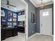 Home office with wood floors, blue walls, and lots of decor, featuring a black desk and white door at 714 S Lois Ave, Tampa, FL 33609