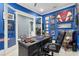 Bright home office with desk, leather chair, and sports memorabilia, showcasing blue walls and ample natural light at 714 S Lois Ave, Tampa, FL 33609