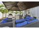 Outdoor patio featuring ample seating with blue cushions, an outdoor kitchen, and a covered gazebo for shade at 714 S Lois Ave, Tampa, FL 33609