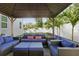 Covered patio with comfortable wicker seating, perfect for outdoor relaxation and entertaining in a lush green space at 714 S Lois Ave, Tampa, FL 33609