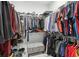 Organized walk-in closet with shelving, hanging racks, and a stylish upholstered ottoman at 714 S Lois Ave, Tampa, FL 33609