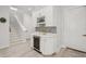 Wet bar nook features a wine rack, cooler, and light gray backsplash adjacent to the staircase and doorways at 714 S Lois Ave, Tampa, FL 33609