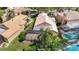 Aerial view of a home featuring a screened-in patio and a private pool surrounded by lush landscaping at 9308 Fairway Lakes Ct, Tampa, FL 33647