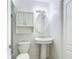 A tidy bathroom with a pedestal sink, mirrored cabinet and white tile at 9308 Fairway Lakes Ct, Tampa, FL 33647