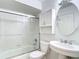 Clean white bathroom with glass shower doors, cabinet and a pedestal sink at 9308 Fairway Lakes Ct, Tampa, FL 33647