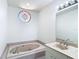 Bathroom with a soaking tub, vanity with marble countertop, and decorative window at 9308 Fairway Lakes Ct, Tampa, FL 33647