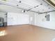 Expansive garage featuring painted walls, floors, and doors, plus garage door opening hardware and modern fixtures at 9308 Fairway Lakes Ct, Tampa, FL 33647