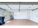 Spacious garage with bright lighting, painted walls, tan-colored floors, and garage door hardware at 9308 Fairway Lakes Ct, Tampa, FL 33647