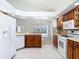 Bright kitchen with white appliances, wooden cabinets, and tile floors creating a functional and appealing cooking area at 9308 Fairway Lakes Ct, Tampa, FL 33647
