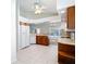 Well-lit kitchen features white appliances, wooden cabinets, and a ceiling fan providing a functional and inviting atmosphere at 9308 Fairway Lakes Ct, Tampa, FL 33647