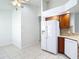 Kitchen featuring wood cabinets, white refrigerator and dishwasher, and tiled floors at 9308 Fairway Lakes Ct, Tampa, FL 33647