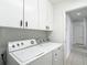 Bright laundry area with white cabinets above appliances at 9308 Fairway Lakes Ct, Tampa, FL 33647