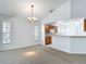 Open-concept living room with ample natural light, neutral carpet and a view to the kitchen at 9308 Fairway Lakes Ct, Tampa, FL 33647