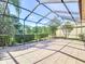 Screened patio offers tiled flooring, exterior views, and ample space for outdoor enjoyment at 9308 Fairway Lakes Ct, Tampa, FL 33647