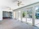 Bright sunroom features carpeting, multiple windows, ceiling fans, and sliding glass doors to the outside at 9308 Fairway Lakes Ct, Tampa, FL 33647