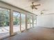 Enclosed sunroom featuring carpeting, ceiling fans, multiple windows, and sliding glass door access to outside at 9308 Fairway Lakes Ct, Tampa, FL 33647