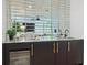 Home bar with mirrored tile backsplash, granite countertop, and wine refrigerator at 98 W Davis Blvd, Tampa, FL 33606
