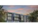 A row of modern townhomes is displayed against an orange and blue sunset with palm trees on the side at 98 W Davis Blvd, Tampa, FL 33606