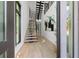 Modern foyer with wood floors, an open staircase, and views of the front yard through a glass front door at 98 W Davis Blvd, Tampa, FL 33606
