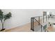 Hallway with hardwood floors and black iron railings leading to a staircase at 98 W Davis Blvd, Tampa, FL 33606