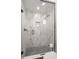 Shower featuring white marble-like tiles, a shower niche, and glass door at 98 W Davis Blvd, Tampa, FL 33606