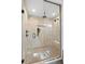 A glass shower enclosure features rainfall shower head and white marble look tiling at 98 W Davis Blvd, Tampa, FL 33606