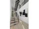 Modern staircase with wood treads, black metal railings, wood floors, and abstract artwork at 98 W Davis Blvd, Tampa, FL 33606