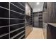 A walk-in closet has rows of open dark wood shelving and drawers, with a blonde wood floor at 98 W Davis Blvd, Tampa, FL 33606