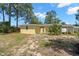 Backyard view showing the exterior of a house with a yellow paint scheme and small yard area at 1019 Goshen Rd, Tarpon Springs, FL 34689