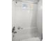 All-white tiled bathroom features a soaking tub, shower head, and natural light at 1019 Goshen Rd, Tarpon Springs, FL 34689