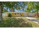 Charming yellow single-story home with a well-manicured front yard and inviting entrance at 1019 Goshen Rd, Tarpon Springs, FL 34689