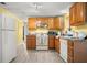 Well-lit kitchen with wood cabinetry and white appliances at 1019 Goshen Rd, Tarpon Springs, FL 34689