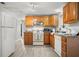 Functional kitchen with white appliances, wood cabinets, and modern flooring at 1019 Goshen Rd, Tarpon Springs, FL 34689