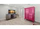 Open living space with a flat screen tv and modern pink storage cabinet at 1019 Goshen Rd, Tarpon Springs, FL 34689