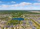 An aerial view captures the neighborhood featuring a scenic lake, surrounded by lush trees and beautiful homes at 11907 Streambed Dr, Riverview, FL 33579