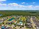 Aerial view of a residential neighborhood with a pool, pond, and green common area under a blue sky at 11907 Streambed Dr, Riverview, FL 33579