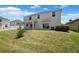 Home exterior showcasing the grassy backyard with a covered patio, fence, and an access door at 11907 Streambed Dr, Riverview, FL 33579