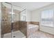 Bright bathroom showcasing a glass-enclosed shower and separate bathtub at 11907 Streambed Dr, Riverview, FL 33579