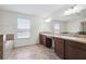 Bright bathroom featuring double vanities, neutral tiling, and a separate tub at 11907 Streambed Dr, Riverview, FL 33579