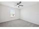 Bright, carpeted bedroom featuring a ceiling fan and a window for natural light at 11907 Streambed Dr, Riverview, FL 33579