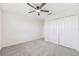 Neutral carpeted bedroom featuring a ceiling fan and a closet with double doors at 11907 Streambed Dr, Riverview, FL 33579