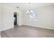 Bright dining room features a chandelier, and wood-look flooring adjacent to an arched entryway and large window at 11907 Streambed Dr, Riverview, FL 33579
