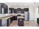 Modern kitchen features dark cabinets, granite countertops, stainless steel appliances, and tile flooring at 11907 Streambed Dr, Riverview, FL 33579
