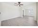 Open-concept living room with wood-look floors, a ceiling fan, and neutral wall paint at 11907 Streambed Dr, Riverview, FL 33579