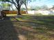 Expansive backyard with a mature tree, complemented by a combination of wood and white fencing at 125 80Th N Ave, St Petersburg, FL 33702
