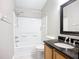 Bathroom featuring a shower-tub combo with tile surround, dark granite counter and wood cabinets at 12508 Evington Point Dr, Riverview, FL 33579