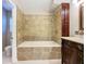 Bathroom featuring a tiled shower-tub combo, vanity with sink, and a decorative dark wood cabinet at 12508 Evington Point Dr, Riverview, FL 33579